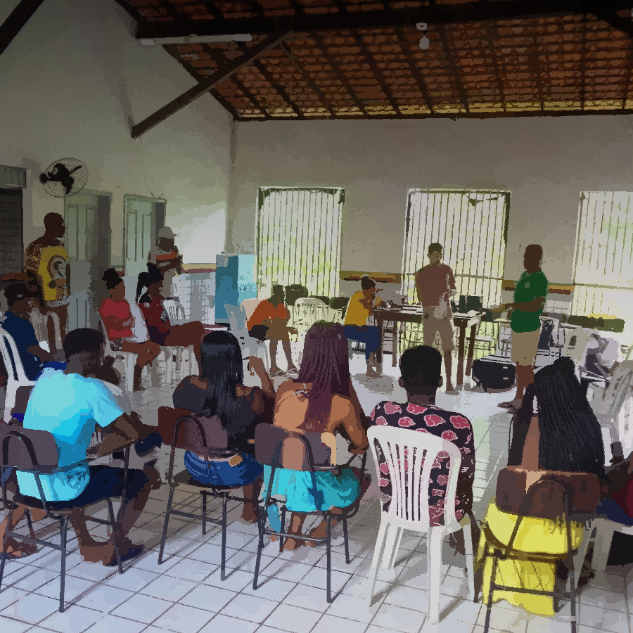 Podemos ver uma sala de aula com a comunidade discutindo o que aprenderam durante as oficinas de redes comunitárias.
